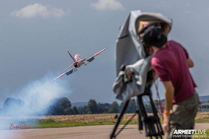 A video cameraman records an rc plane taking off from the runway